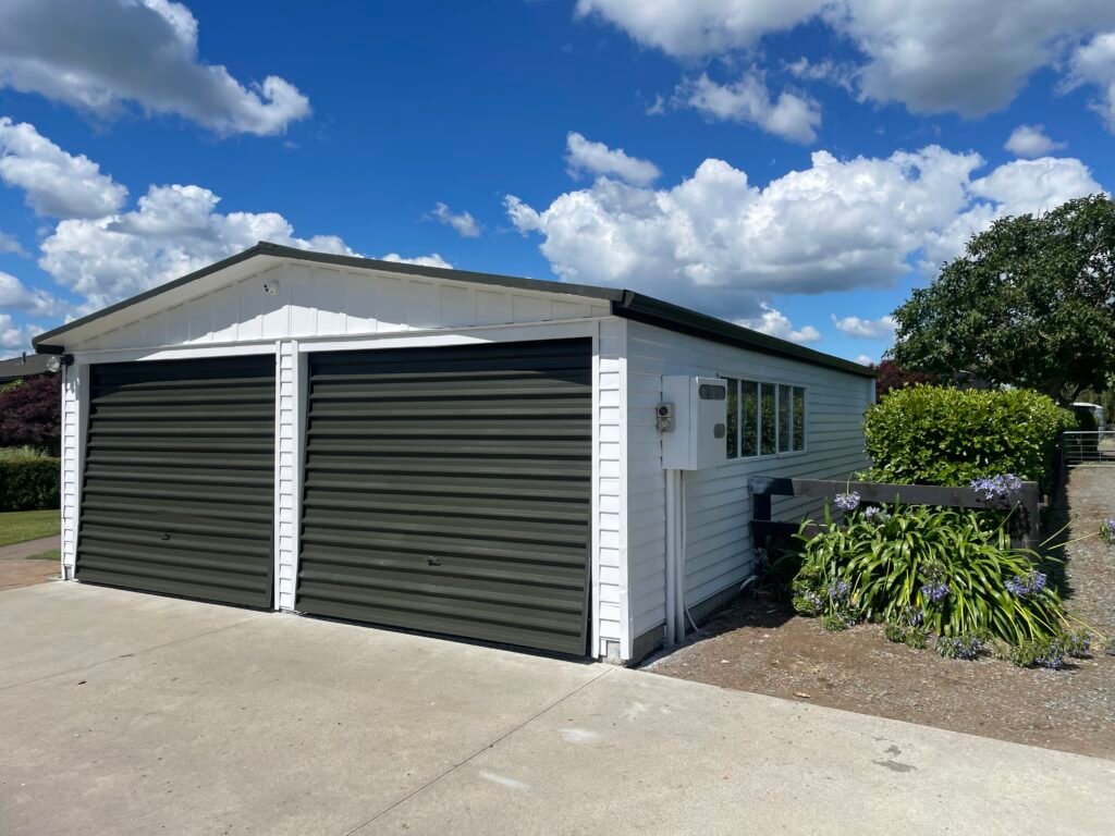 Contemporary exterior painting finish on a grey home with black garage door in Hamilton by Tomar Contracting